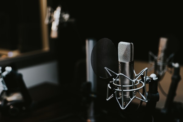 Zwei Studio-Mikrofone auf Stativen in stimmungsvollem Licht